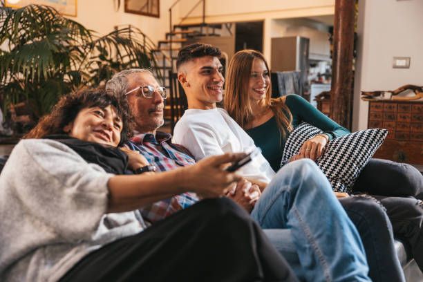 Happy family relaxing and watching HolyIPTV streaming service together on sofa