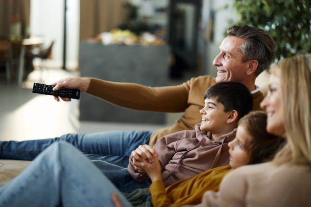 Happy family watching HolyIPTV on their home television