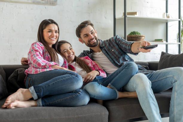Family watching IPTV television together in a comfortable living room setting