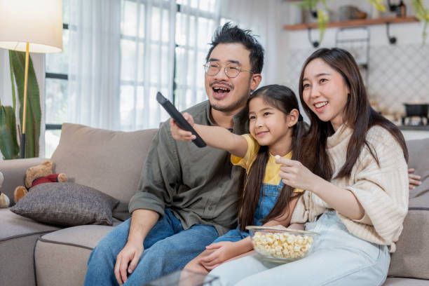 Young Swiss family watching HolyIPTV together at home and enjoying streaming